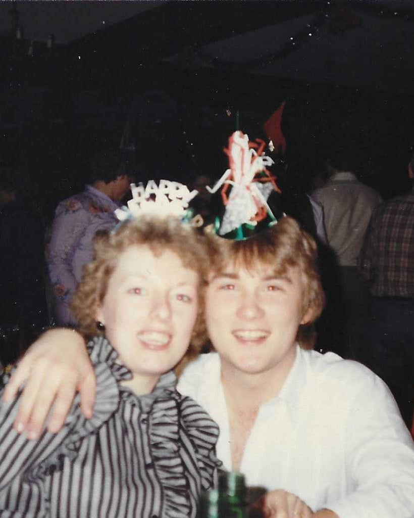 Mike and his wife Evelyn in the 1980's celebrating with party hats at a festive event.
