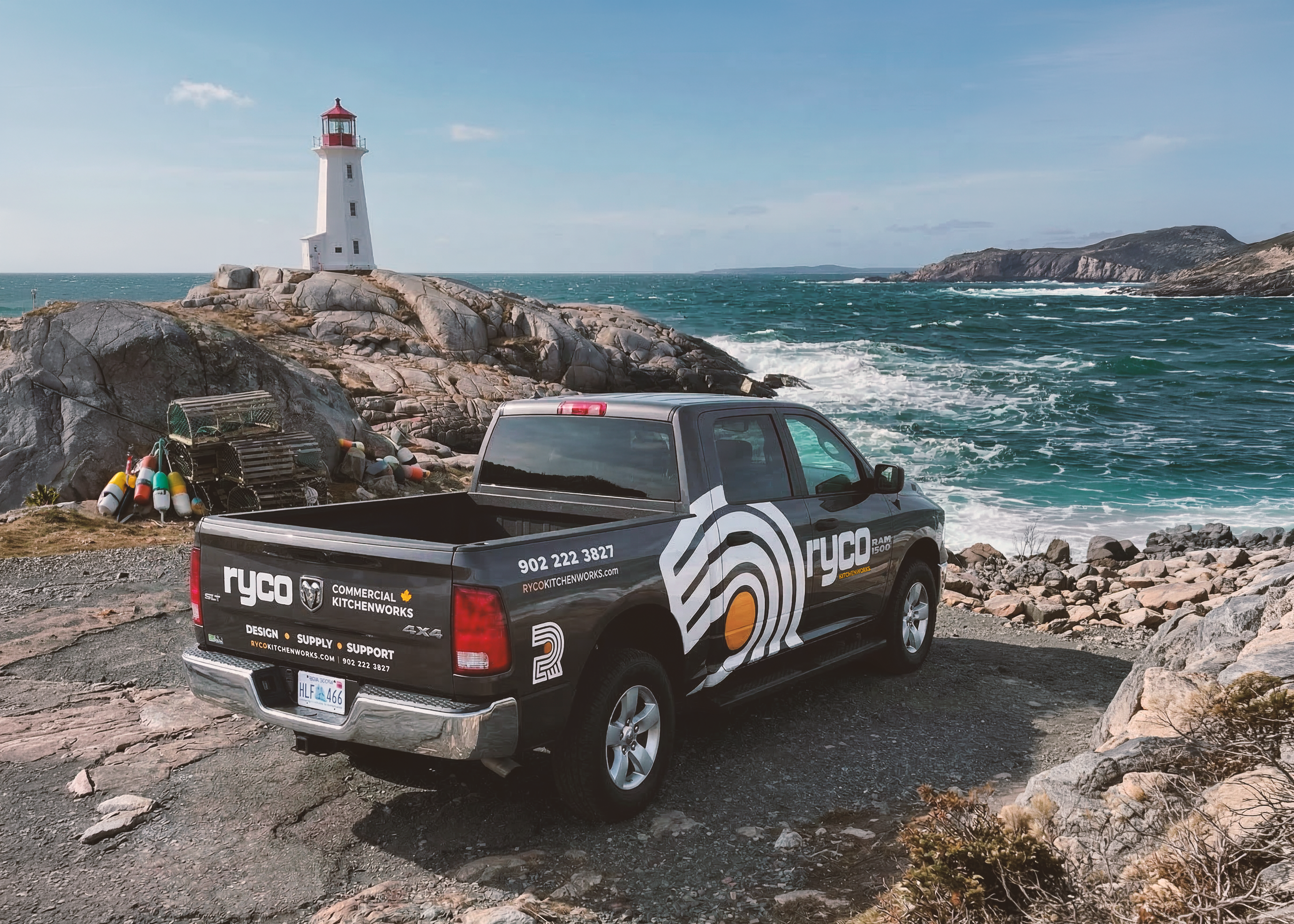 RYCO Company truck parked near the shoreline with a lighthouse and ocean in the background
